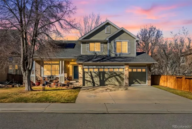 a front view of a house with a yard and trees