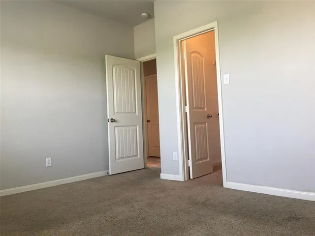 an empty room with closet and a window
