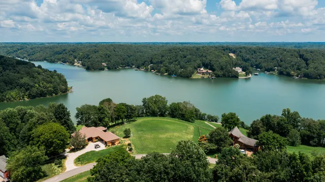 an aerial view of a house with a yard and lake view