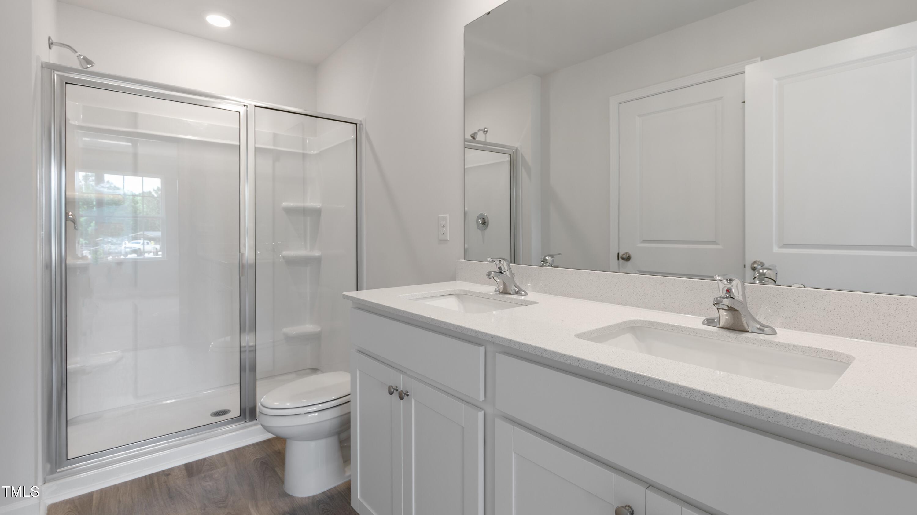 59 Virgo Drive Angier, NC 27501 - Photo 23 of 32 a bathroom with a shower sink vanity mirror and toilet