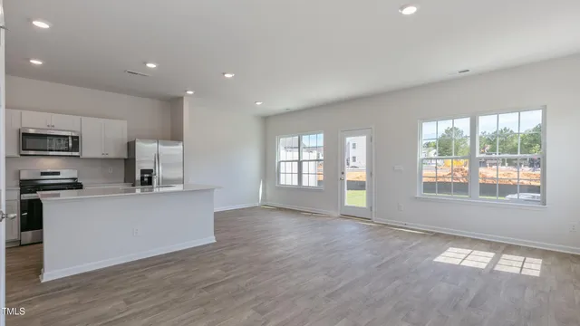 a kitchen with stainless steel appliances a refrigerator sink and stove top oven