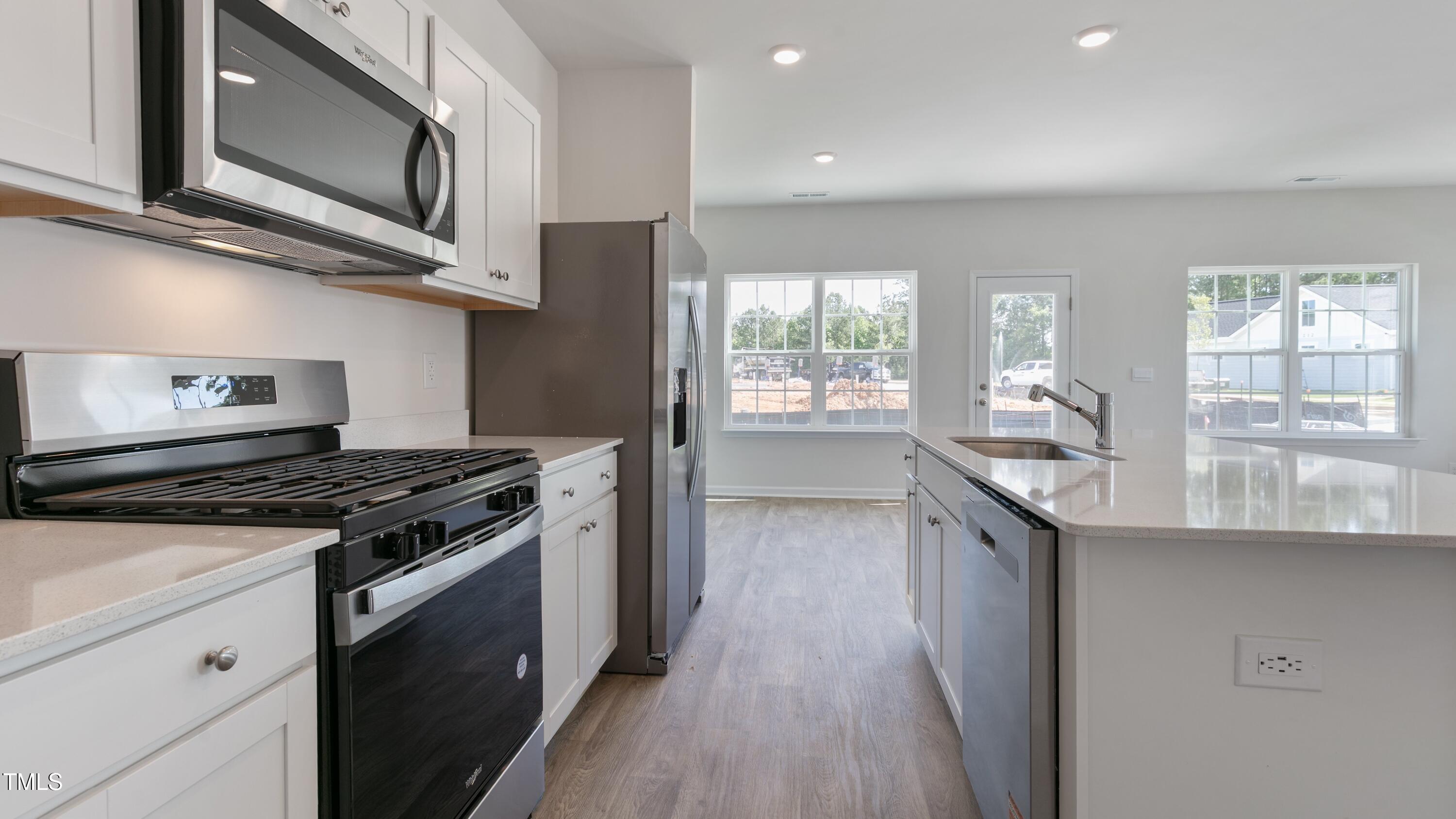 59 Virgo Drive Angier, NC 27501 - Photo 9 of 32 a kitchen with stainless steel appliances granite countertop a stove and a sink