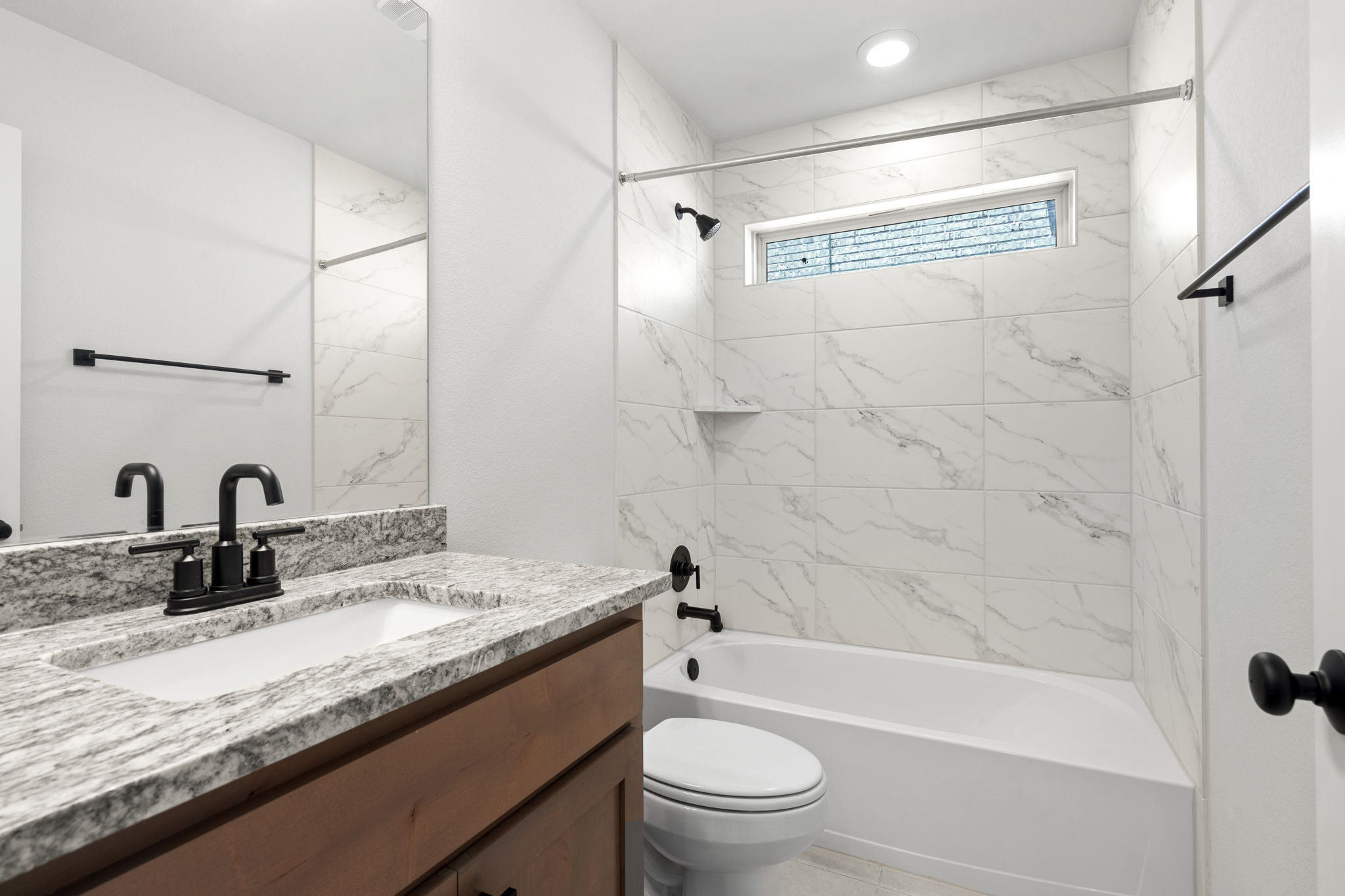 341 Fawn Riv Run Kyle, TX 78640 - Photo 18 of 29 a bathroom with a granite countertop sink a toilet and shower