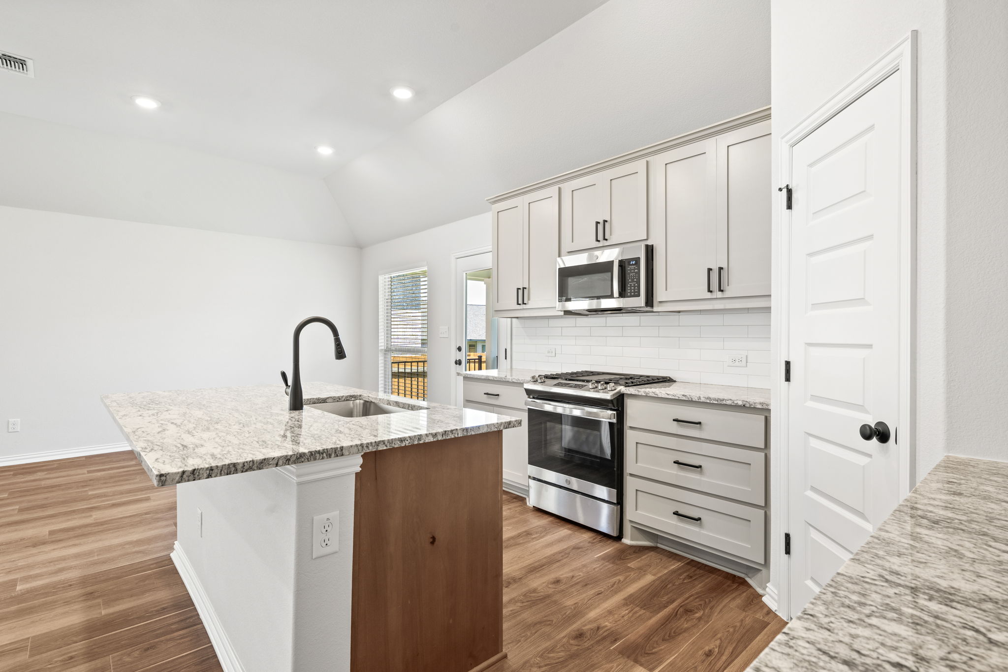 341 Fawn Riv Run Kyle, TX 78640 - Photo 6 of 29 a kitchen with stainless steel appliances granite countertop a stove a sink and a refrigerator