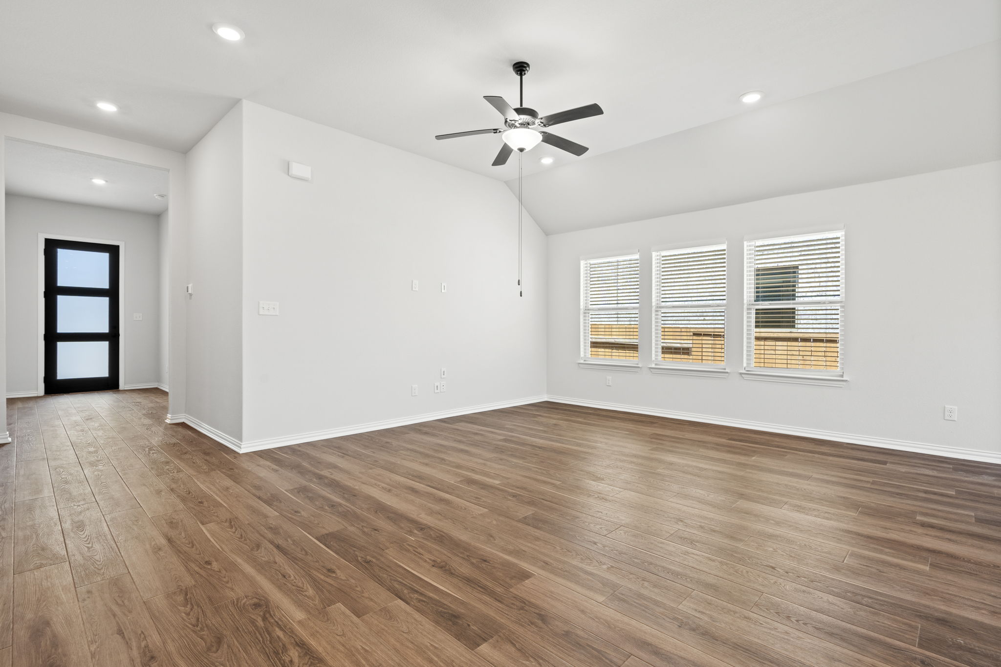 341 Fawn Riv Run Kyle, TX 78640 - Photo 8 of 29 a view of an empty room with wooden floor and a window