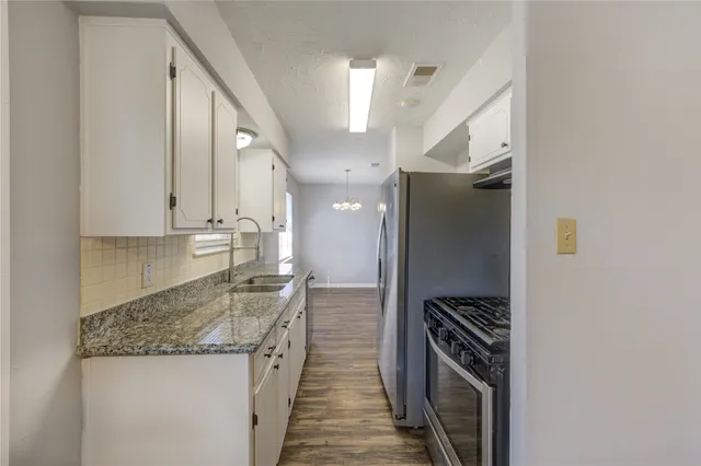 a kitchen with stainless steel appliances granite countertop a sink and a refrigerator