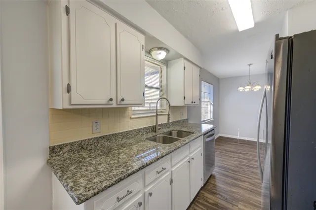 a kitchen with granite countertop a sink and cabinets