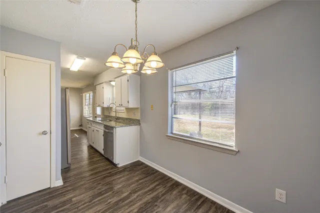 a view of a room with a kitchen island wooden floor and windows