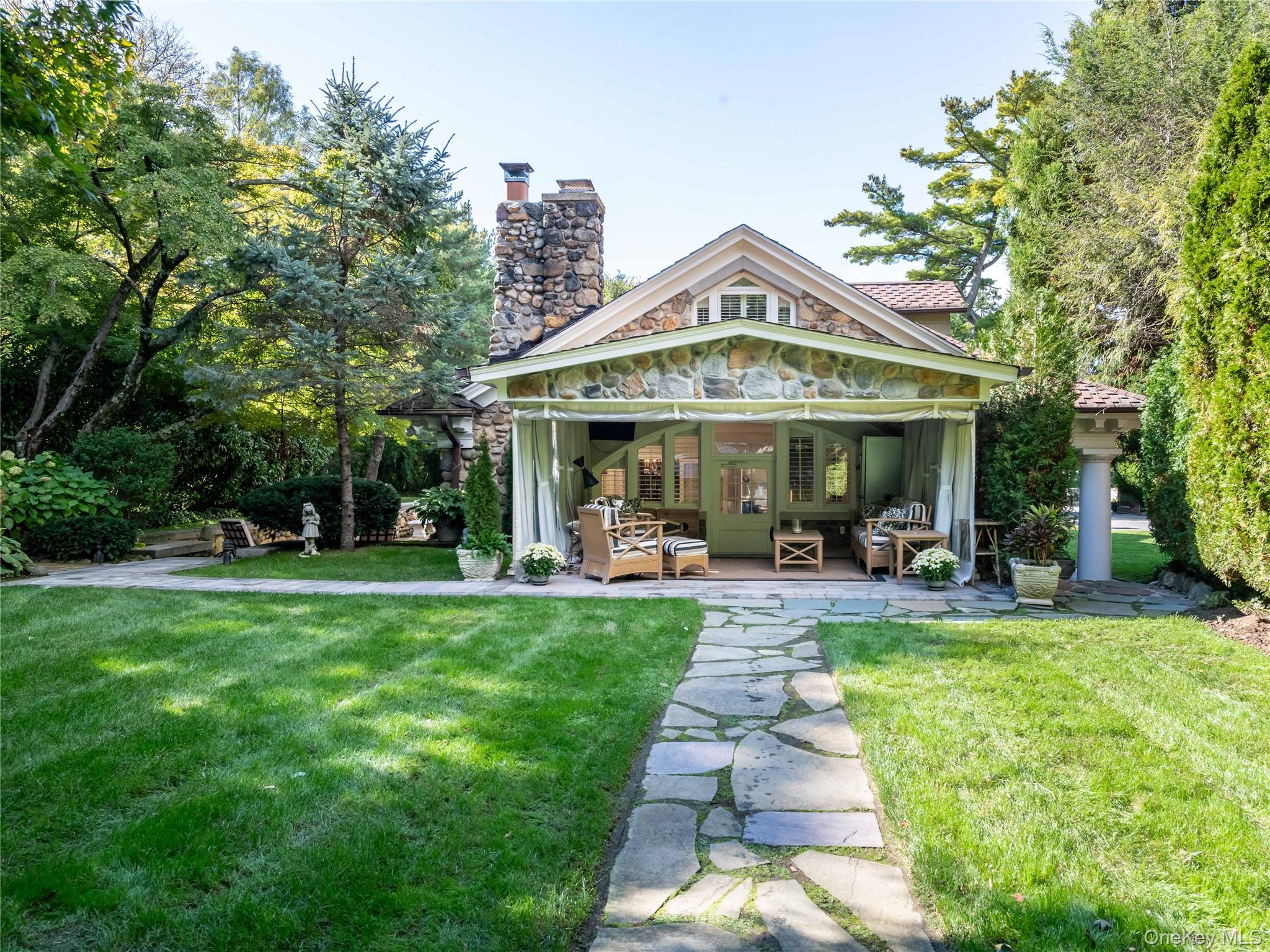 1054 Plandome Road Manhasset, NY 11030 - Photo 23 of 47 a view of a house with a yard patio and swimming pool