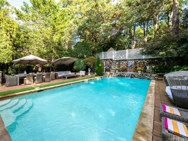 a view of a swimming pool with lounge chairs in patio
