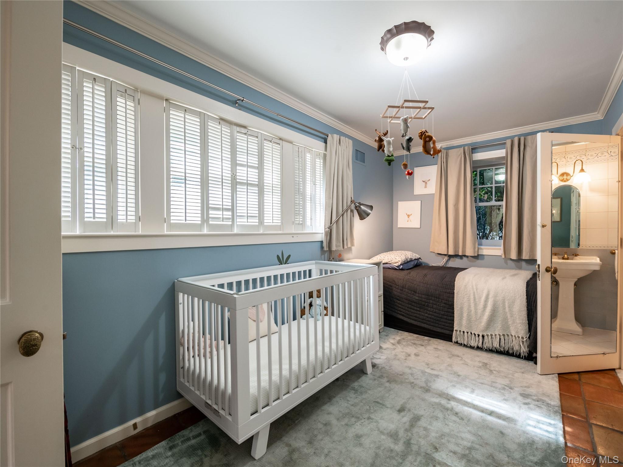 1054 Plandome Road Manhasset, NY 11030 - Photo 32 of 47 a bedroom with windows and a chandelier