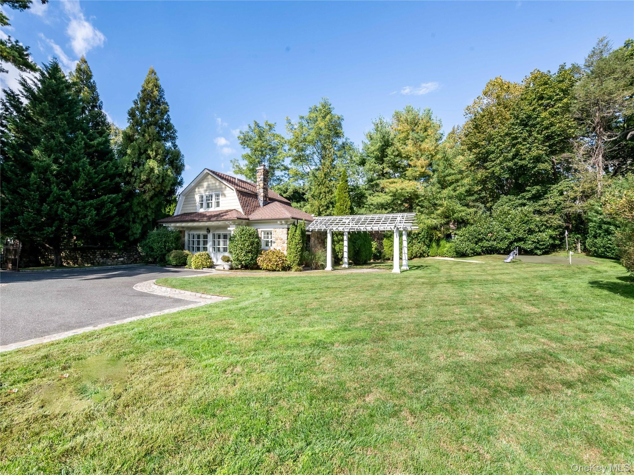 1054 Plandome Road Manhasset, NY 11030 - Photo 35 of 47 a front view of a house with a yard
