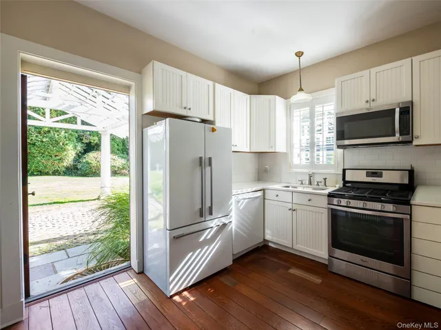 a kitchen with stainless steel appliances a stove a sink and a microwave