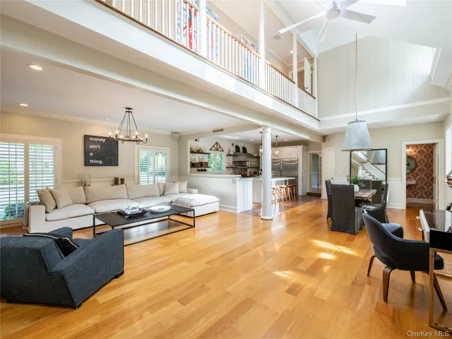 a living room with furniture kitchen view and a large window