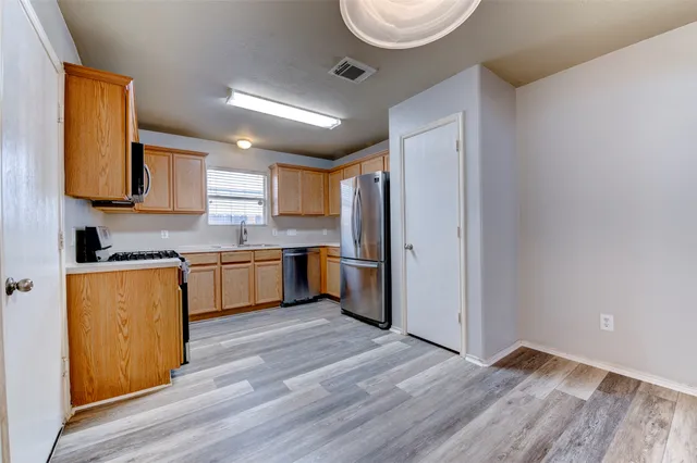 a kitchen with stainless steel appliances granite countertop a refrigerator stove top oven a sink and dishwasher