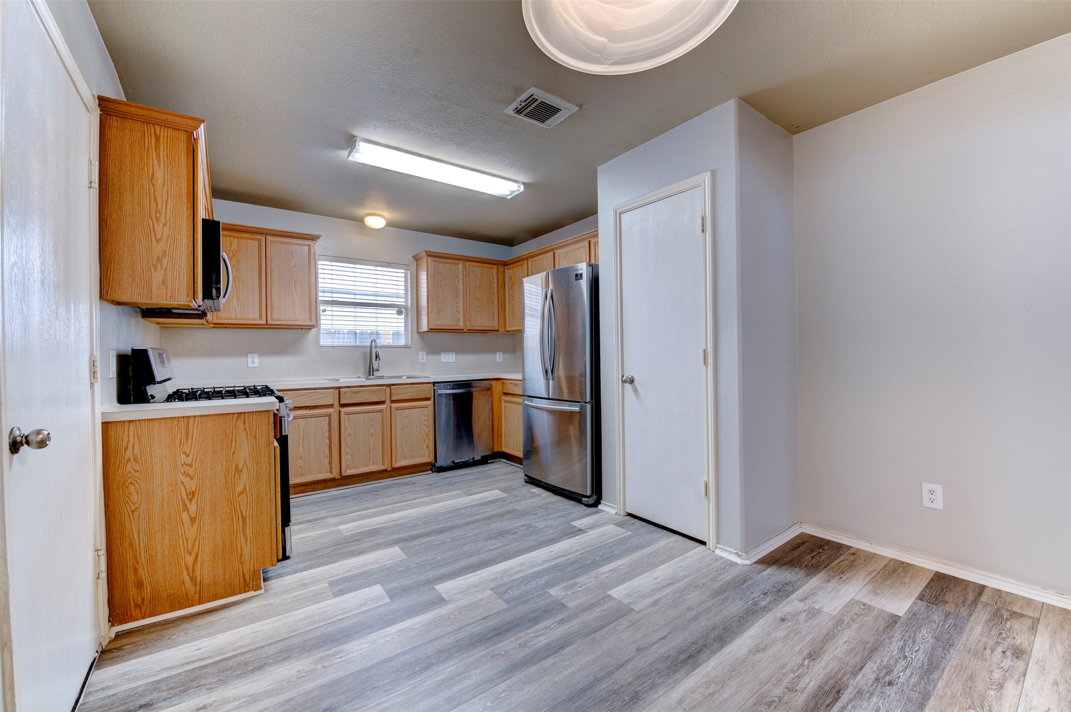 16143 Bantam Ridge Court Houston, TX 77053 - Photo 9 of 18 a kitchen with granite countertop wooden floors a stove and a refrigerator