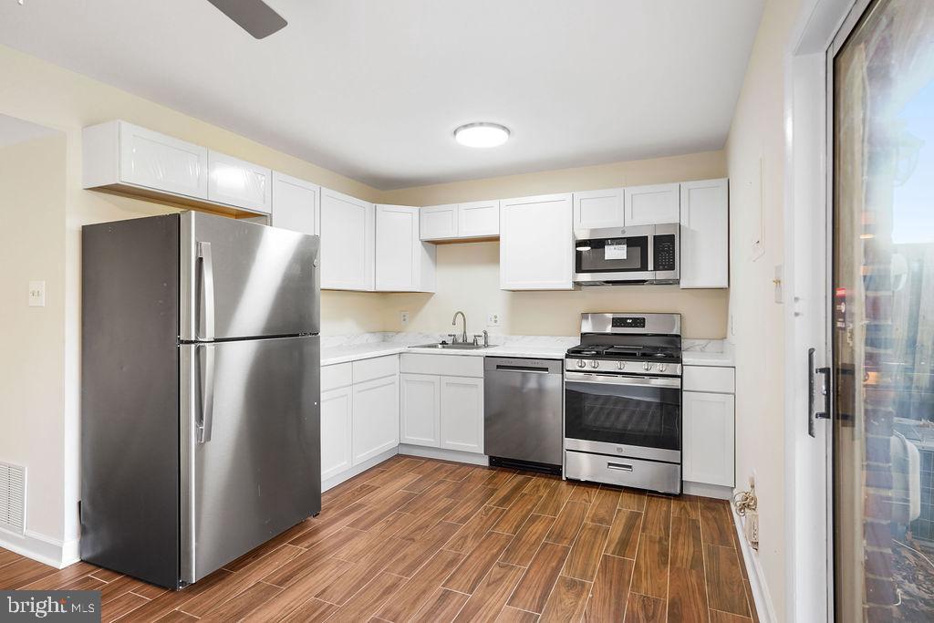 2201 Chamblee Place Herndon, VA 20170 - Photo 6 of 31 a kitchen with a refrigerator stove and wooden floor