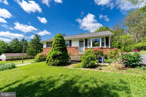 a view of a house with a yard and potted plants