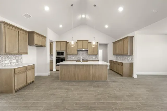 a large kitchen with kitchen island a sink stainless steel appliances and cabinets