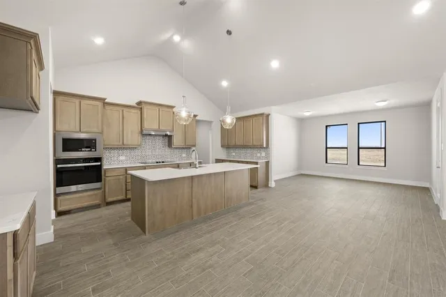 a large kitchen with kitchen island a sink stainless steel appliances and cabinets
