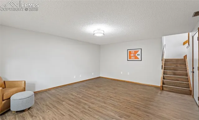 a room with a wooden floor and next to a window