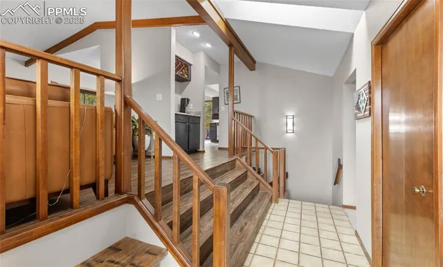 a kitchen with stainless steel appliances a stove top oven a refrigerator a dining table and chairs with wooden floor