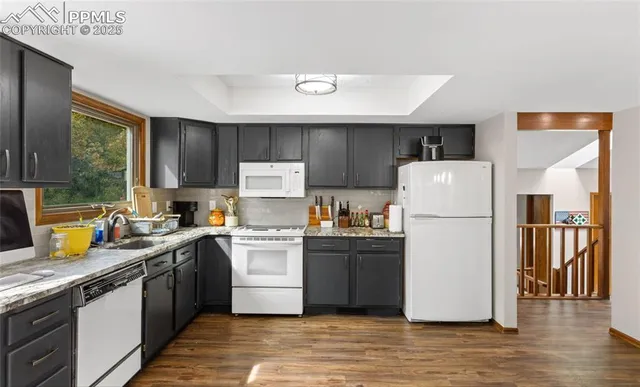 a kitchen view with granite countertop a sink and a stove top oven