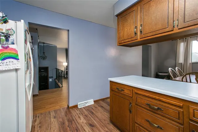 a kitchen with wooden floor and cabinets