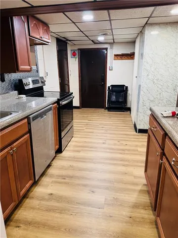 a kitchen with stainless steel appliances wooden cabinets a sink and a stove