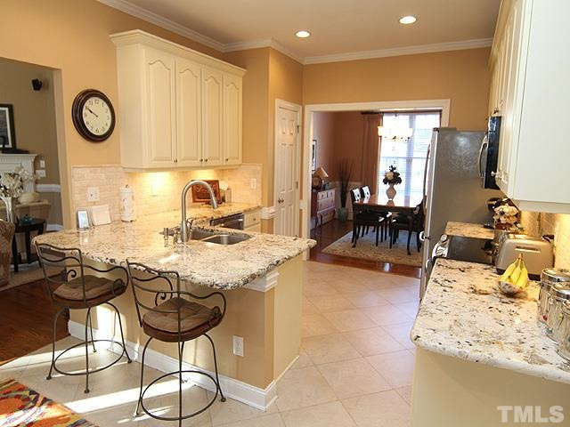 11618 John Allen Road Raleigh, NC 27614 - Photo 10 of 25 Tons of cabinet space in this home! Neutral color cabinets to match any décor, tile floors, new ss appliances, must see gorgeous granite counters, and come sit down at your bar and have some coffee and watch the chef prepare meals in your beautiful kitch Kitchen