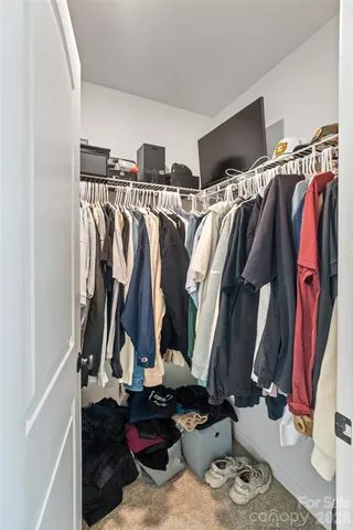 a view of walk in closet with clothes