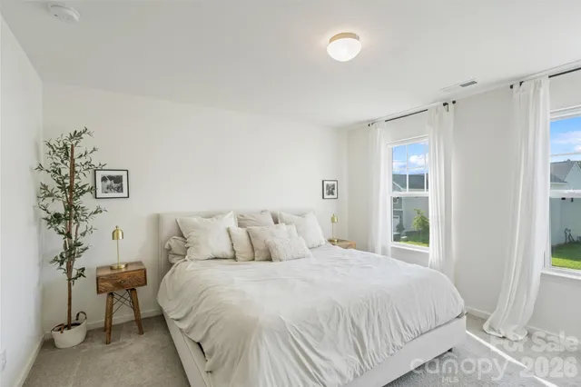 a bedroom with a bed and a flat tv screen on wall
