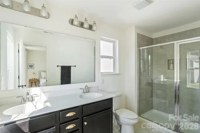 a bathroom with a shower a toilet and a sink