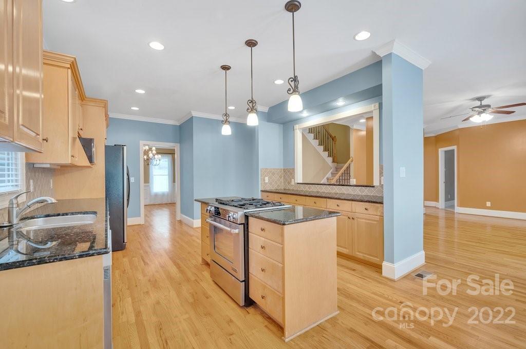 656 Amberly Crossing Fort Mill, SC 29708 - Photo 11 of 44 a kitchen with granite countertop a stove a sink a refrigerator and a wooden floor