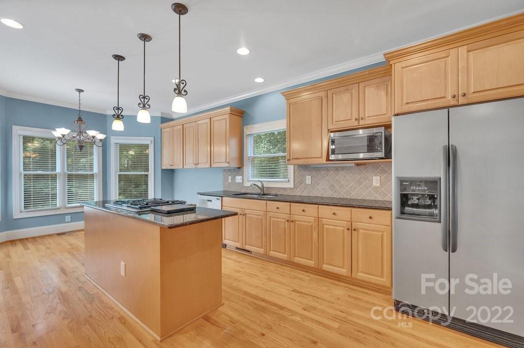 656 Amberly Crossing Fort Mill, SC 29708 - Photo 12 of 44 a kitchen with stainless steel appliances granite countertop a stove a refrigerator and a sink with wooden floor