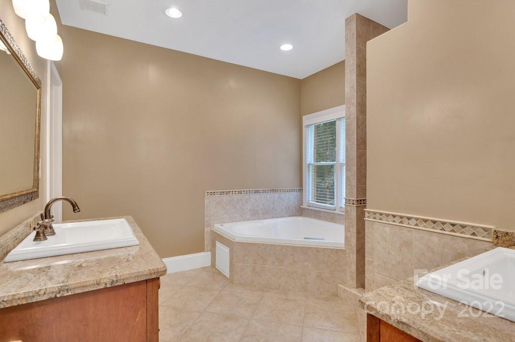 656 Amberly Crossing Fort Mill, SC 29708 - Photo 18 of 44 a bathroom with a granite countertop sink and a bathtub