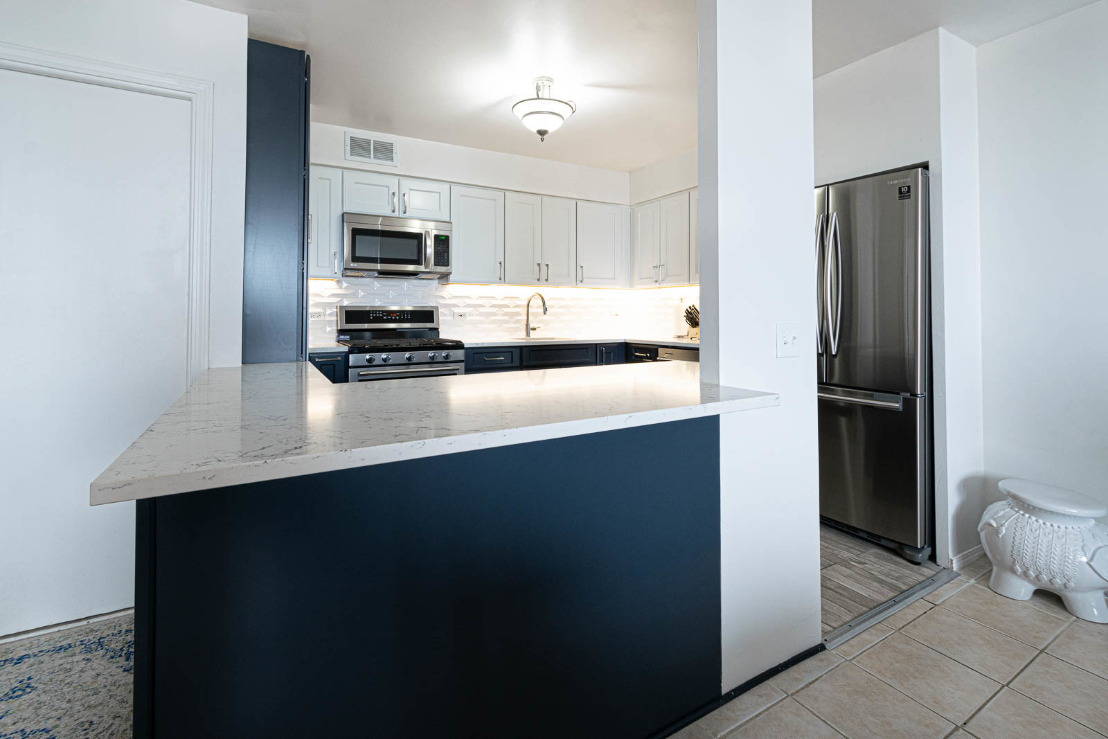 6325 North Sheridan Road, Unit 1508 Chicago, IL 60660 - Photo 5 of 16 a kitchen with stainless steel appliances a refrigerator and a stove