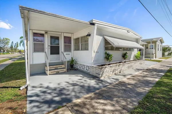 a view of a house with backyard and sitting area