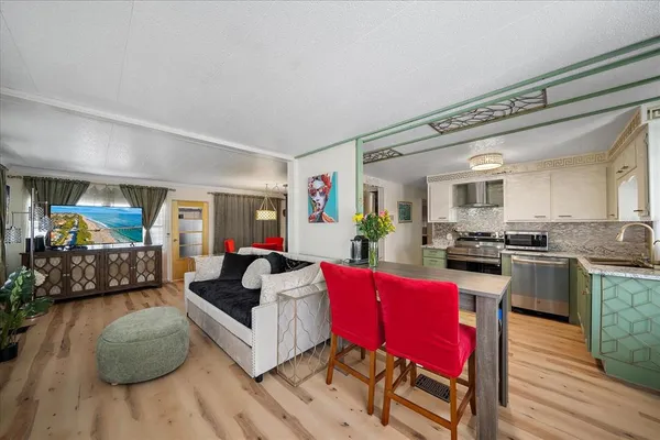 a living room with furniture a flat screen tv and a large window
