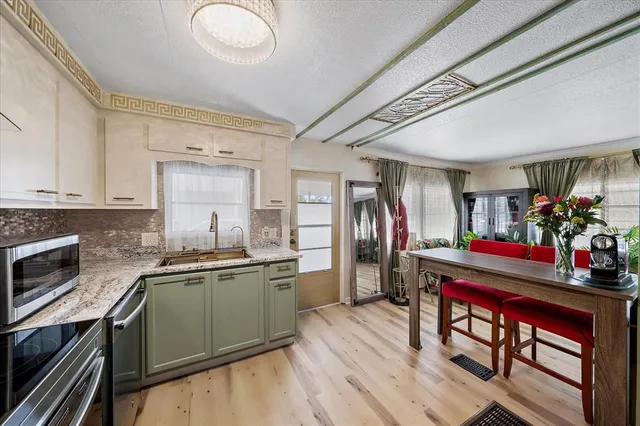 a kitchen that has a lot of cabinets a sink and appliances in it