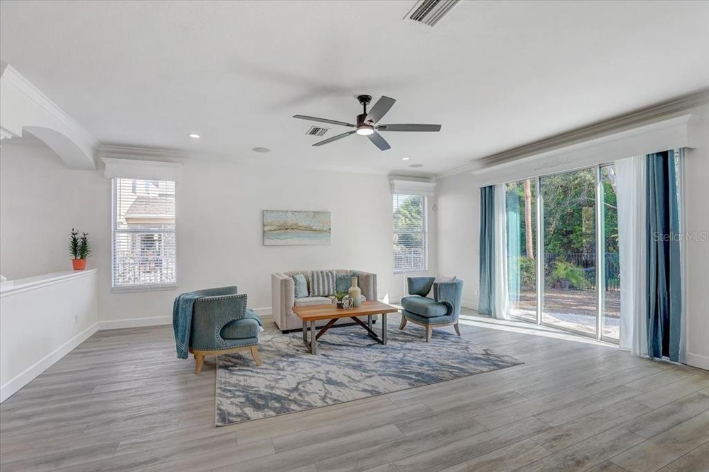 4006 91st Avenue East Parrish, FL 34219 - Photo 11 of 48 a living room with furniture floor to ceiling window and wooden floor
