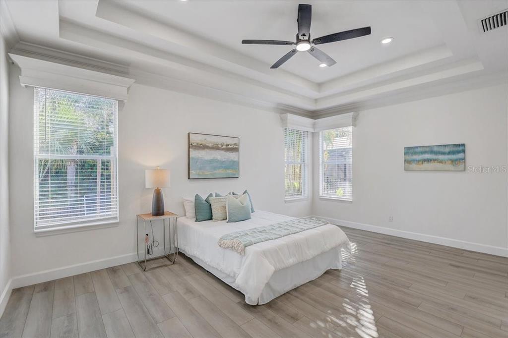 4006 91st Avenue East Parrish, FL 34219 - Photo 20 of 48 a bedroom with a large bed chandelier and a window