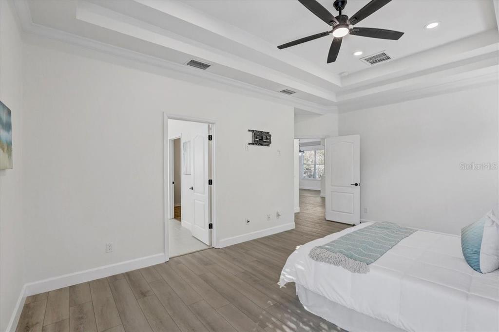 4006 91st Avenue East Parrish, FL 34219 - Photo 22 of 48 a bedroom with a large bed and a chandelier fan