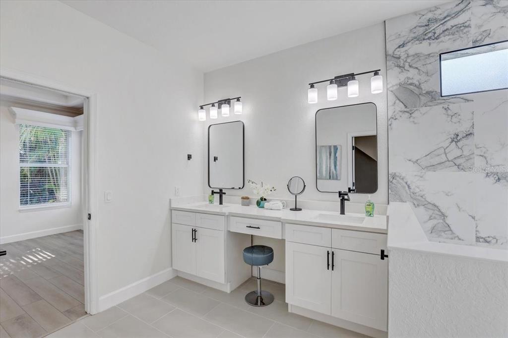 4006 91st Avenue East Parrish, FL 34219 - Photo 24 of 48 a bathroom with a double vanity sink a mirror and a