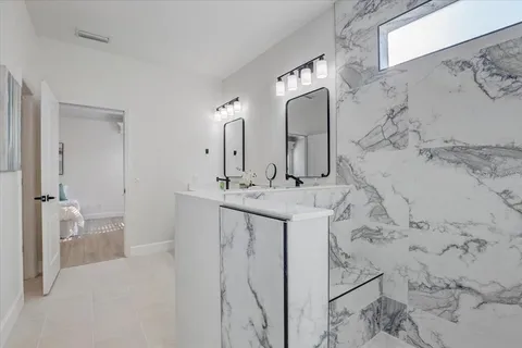 a spacious bathroom with a double vanity sink and mirror