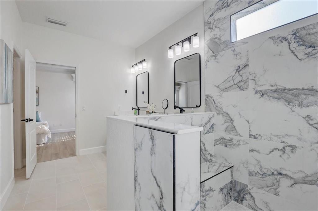4006 91st Avenue East Parrish, FL 34219 - Photo 25 of 48 a spacious bathroom with a double vanity sink and mirror