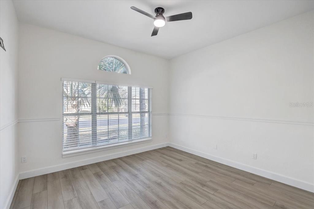 4006 91st Avenue East Parrish, FL 34219 - Photo 27 of 48 an empty room with wooden floor fan and windows