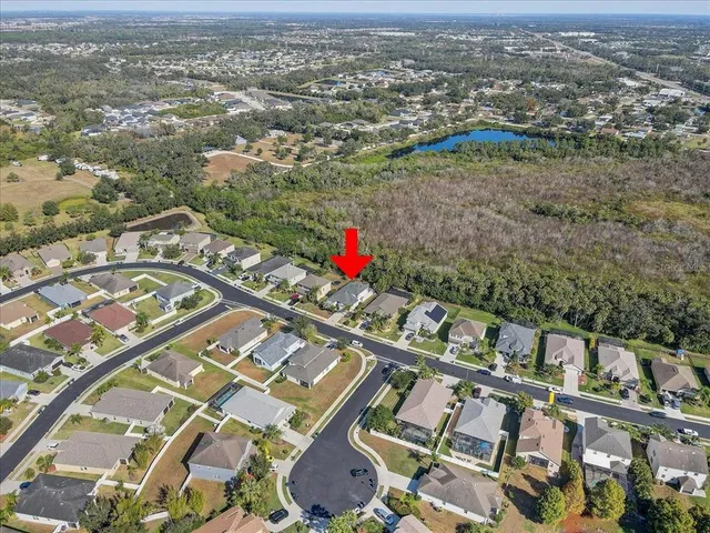 an aerial view of residential houses with outdoor space and trees