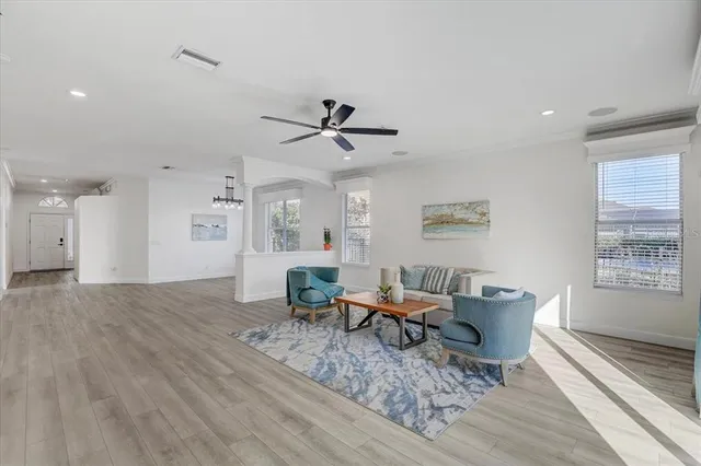 a living room with furniture a window and wooden floor