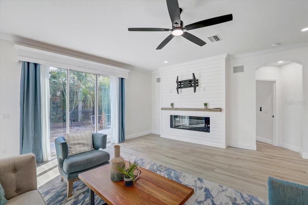 4006 91st Avenue East Parrish, FL 34219 - Photo 9 of 48 a living room with furniture a fireplace and a floor to ceiling window